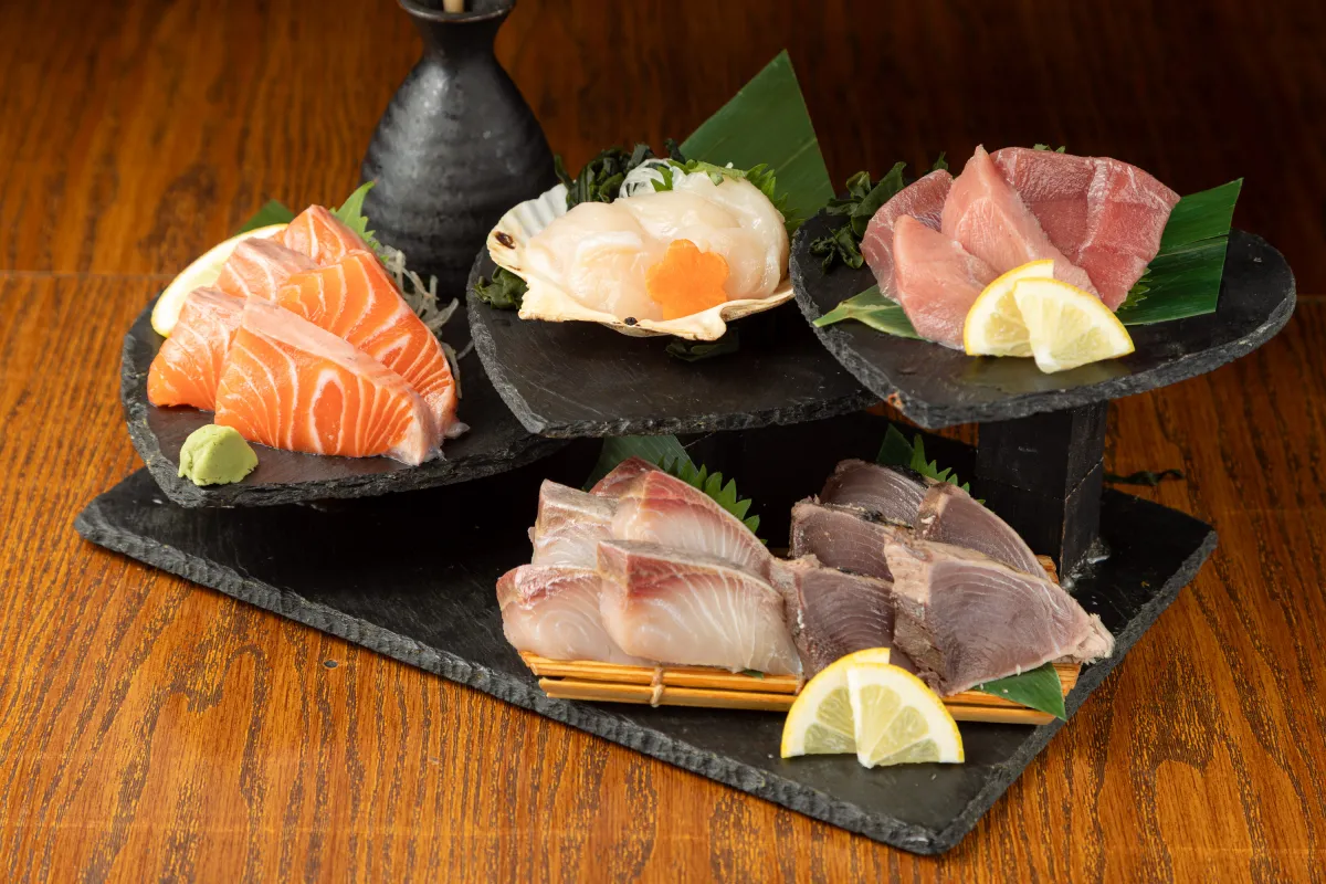 サーモンやホタテなどの刺身盛り合わせと日本酒の徳利